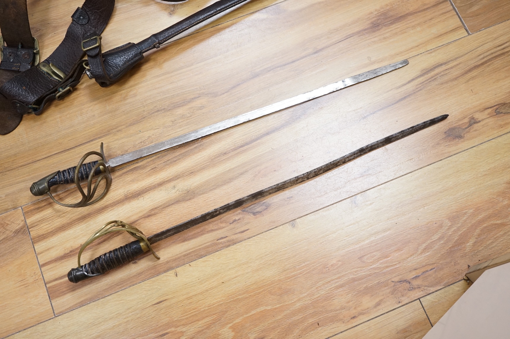 Two early 20th century Imperial German child’s swords with leather scabbards and hangers, blades 45.5cm
